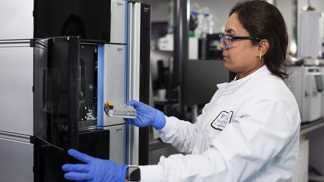 woman putting specimens into lab equipment