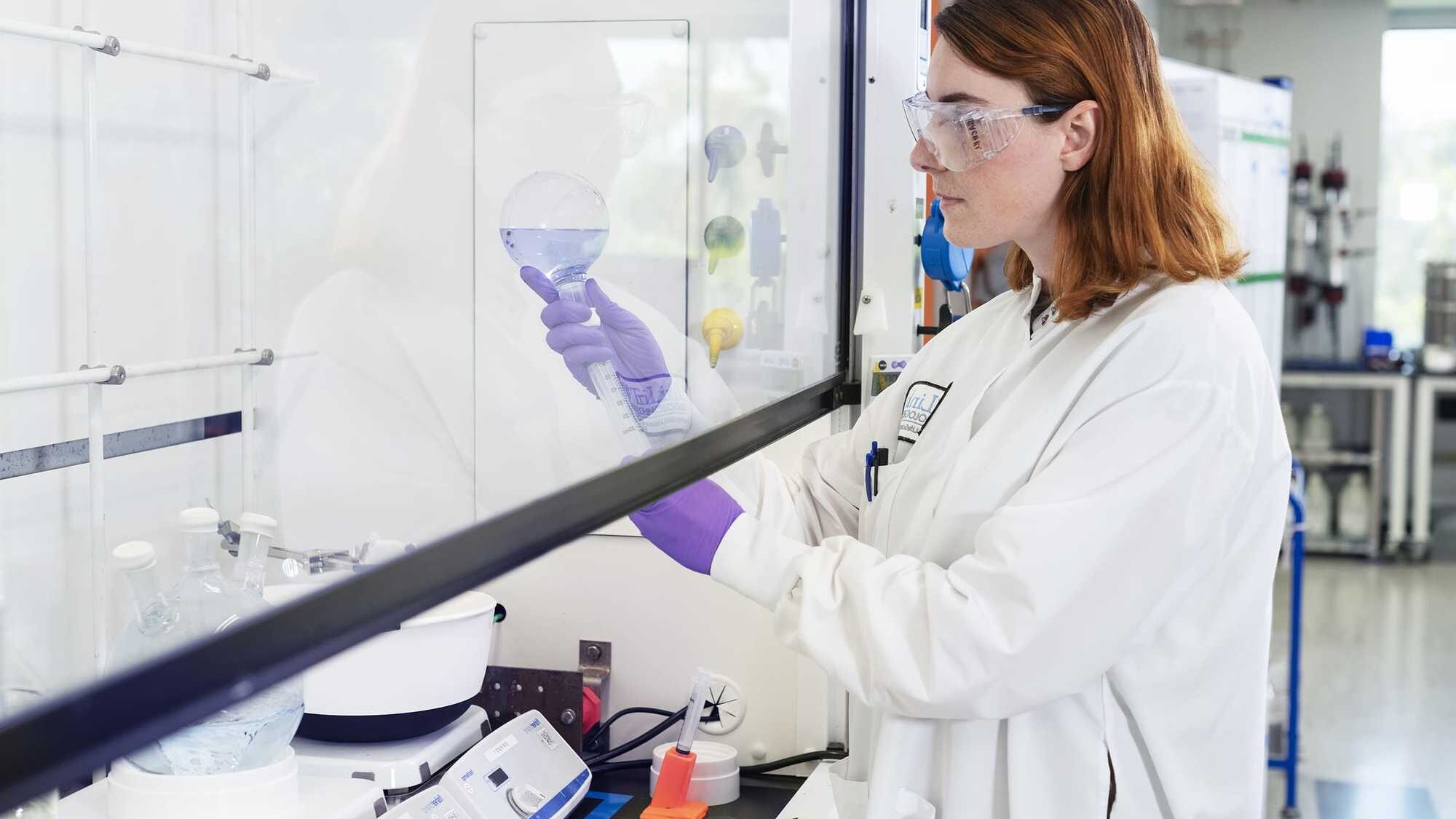 woman handing lab equipment